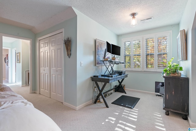 carpeted bedroom with ceiling fan, a textured ceiling, and a closet