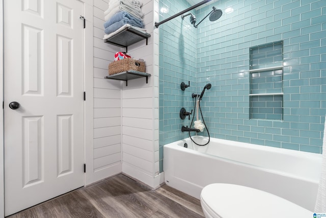 bathroom featuring toilet, tiled shower / bath, and wood-type flooring