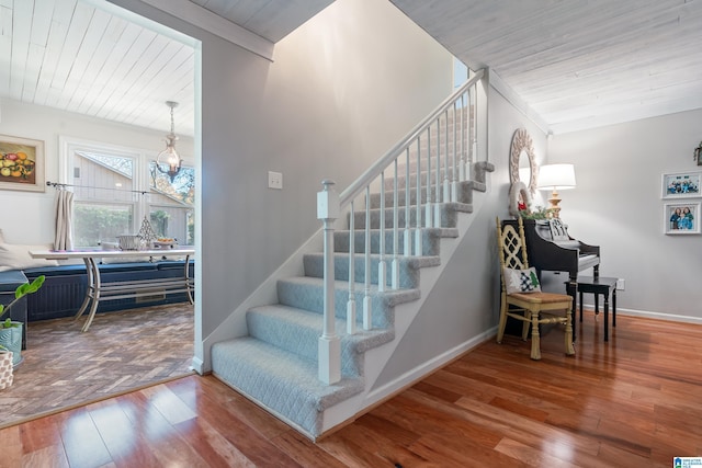 stairs featuring wooden ceiling and hardwood / wood-style flooring