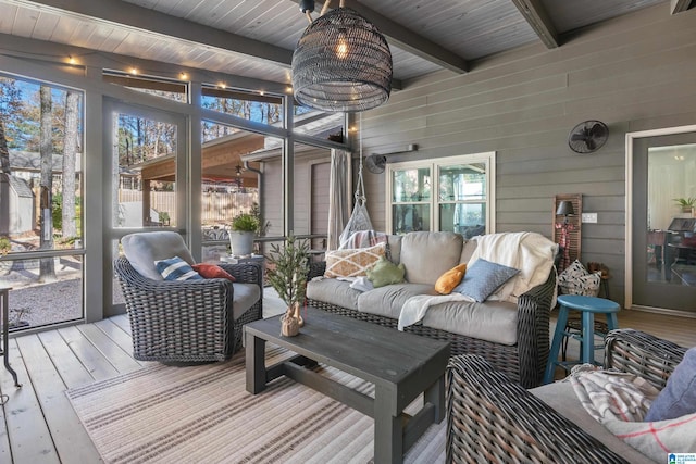 sunroom / solarium featuring beamed ceiling