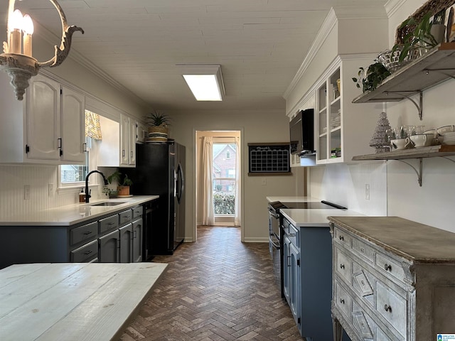 kitchen with white cabinetry, black dishwasher, backsplash, crown molding, and sink