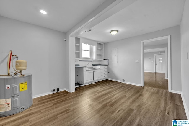 kitchen with water heater, white cabinetry, tasteful backsplash, sink, and dark hardwood / wood-style floors