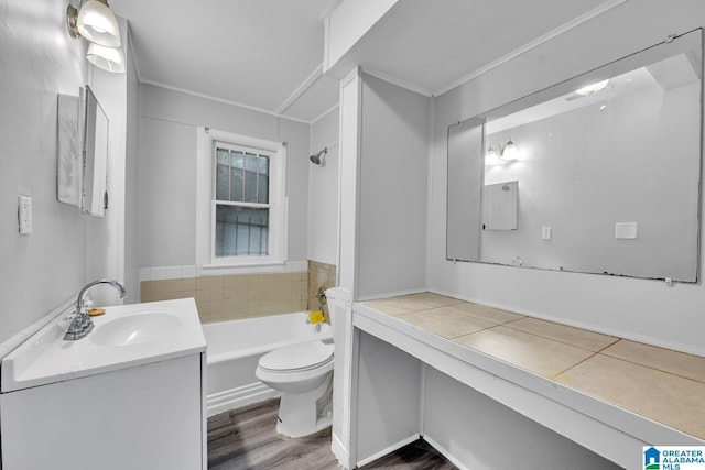 bathroom featuring toilet, ornamental molding, a bath, and vanity