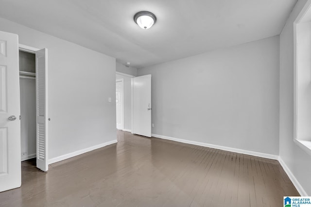 unfurnished bedroom with a closet and dark hardwood / wood-style flooring