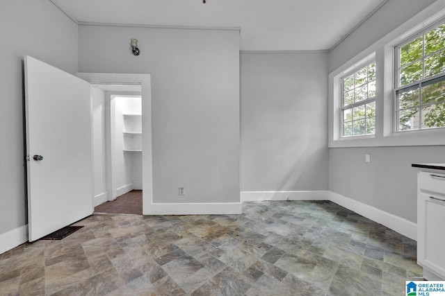 empty room featuring crown molding