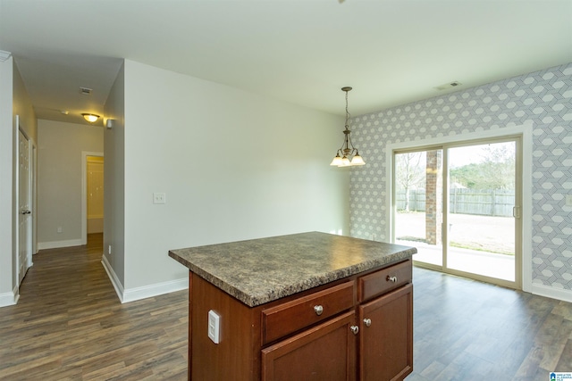 kitchen featuring decorative light fixtures, dark hardwood / wood-style flooring, a chandelier, and a center island