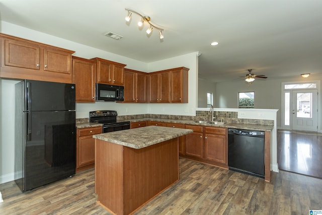 kitchen featuring ceiling fan, dark hardwood / wood-style floors, a center island, black appliances, and sink