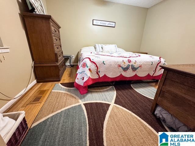 bedroom featuring light hardwood / wood-style floors and a textured ceiling