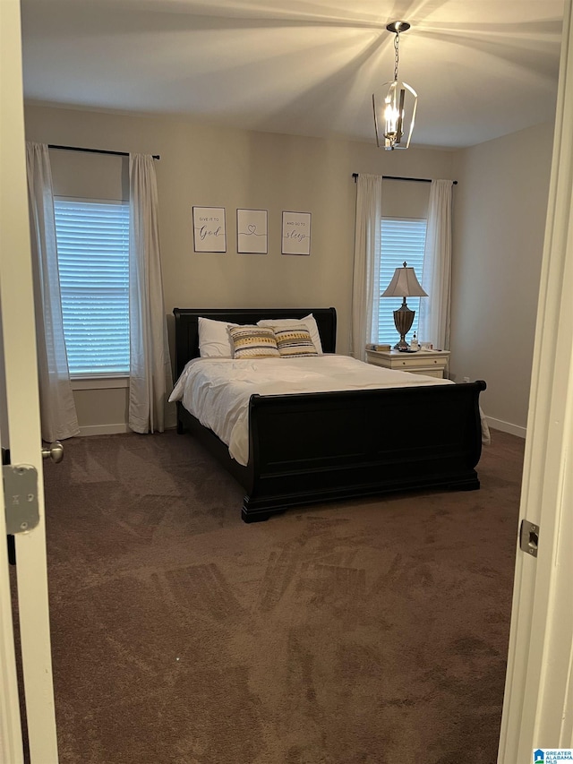 carpeted bedroom featuring multiple windows and a chandelier