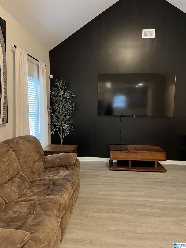 living room with vaulted ceiling and light hardwood / wood-style floors