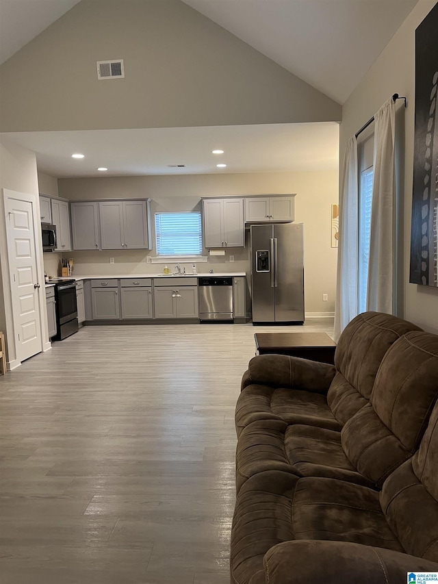 kitchen featuring sink, appliances with stainless steel finishes, gray cabinetry, and light wood-type flooring