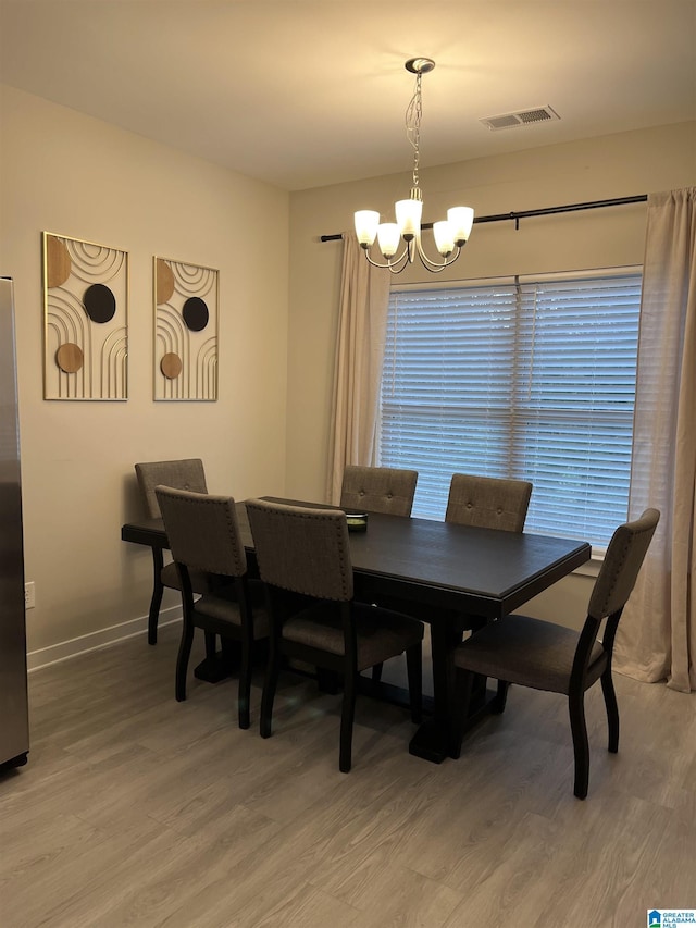 dining space with a wealth of natural light, a chandelier, and hardwood / wood-style flooring