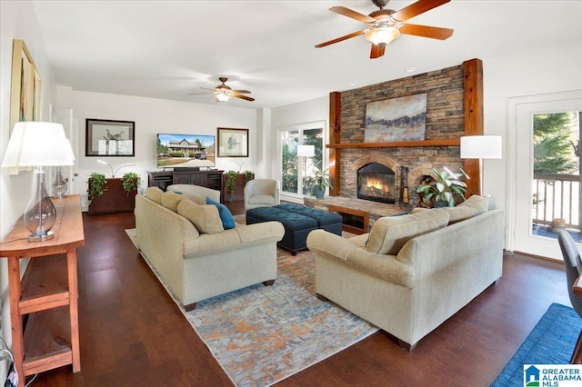 living room featuring a stone fireplace, dark hardwood / wood-style floors, and ceiling fan