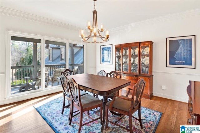 dining space featuring ornamental molding, a chandelier, and light hardwood / wood-style floors