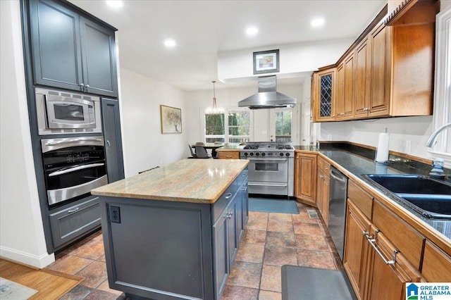 kitchen with a center island, ventilation hood, gray cabinets, stainless steel appliances, and light stone countertops