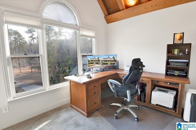 carpeted office featuring vaulted ceiling with beams