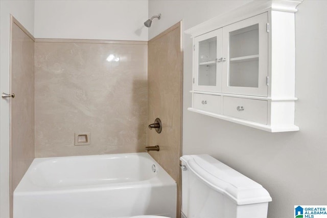 bathroom with toilet and tiled shower / bath