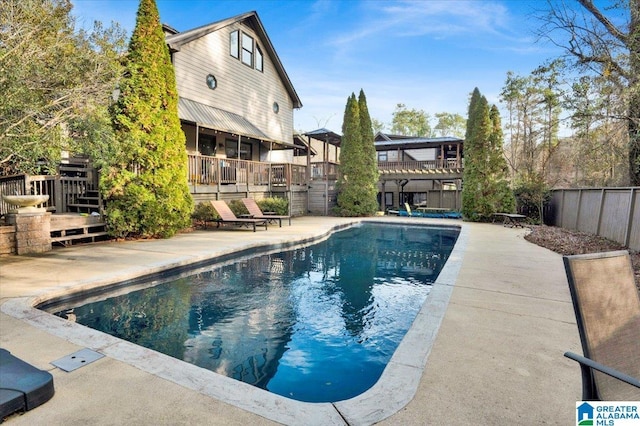 view of pool with a wooden deck and a patio