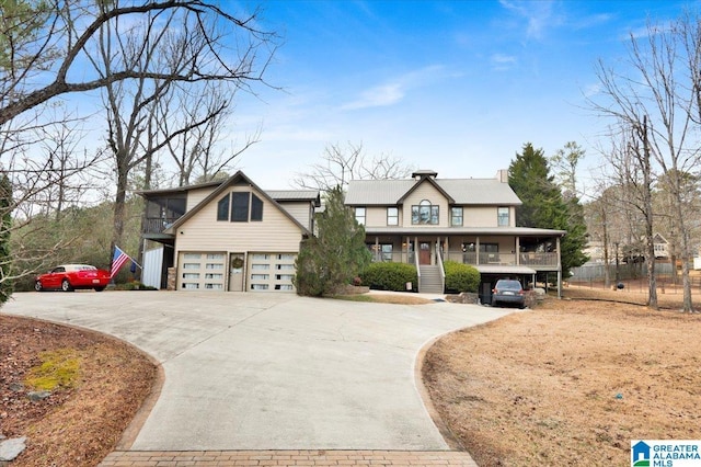 view of front of property featuring a garage, a sunroom, and covered porch