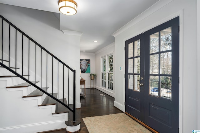 foyer entrance featuring crown molding, dark hardwood / wood-style floors, a wealth of natural light, and french doors