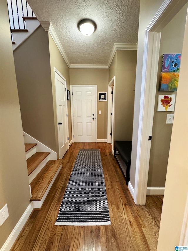 entryway with crown molding, a textured ceiling, and hardwood / wood-style flooring