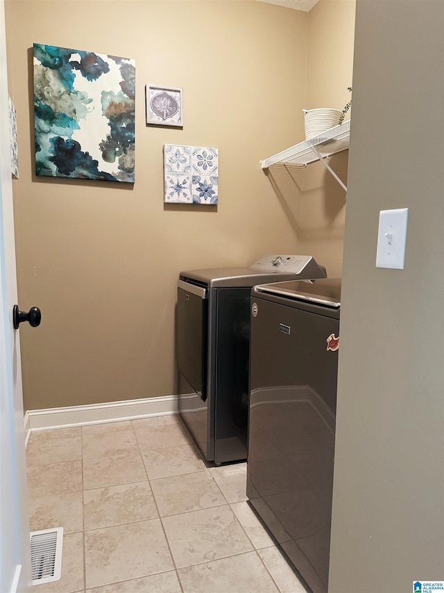 washroom featuring washing machine and dryer and light tile patterned floors