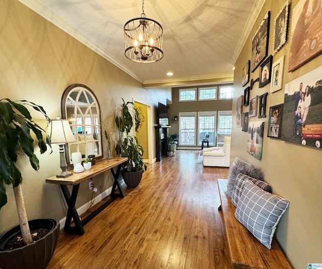 hallway with hardwood / wood-style floors, crown molding, a notable chandelier, and a textured ceiling