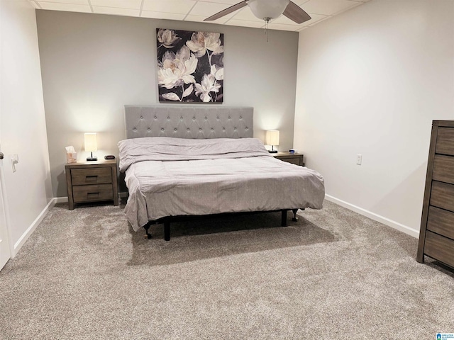 bedroom featuring ceiling fan, a drop ceiling, and carpet