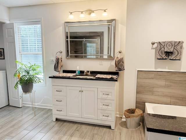 bathroom with a tub to relax in, hardwood / wood-style floors, and vanity