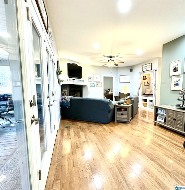 living room with ceiling fan, french doors, and light hardwood / wood-style flooring