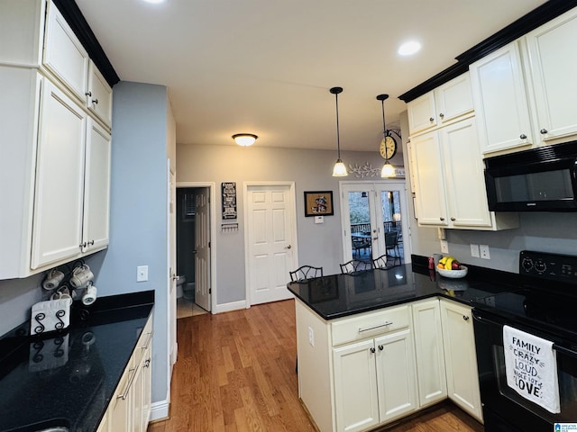 kitchen with white cabinets, black appliances, decorative light fixtures, kitchen peninsula, and light hardwood / wood-style flooring