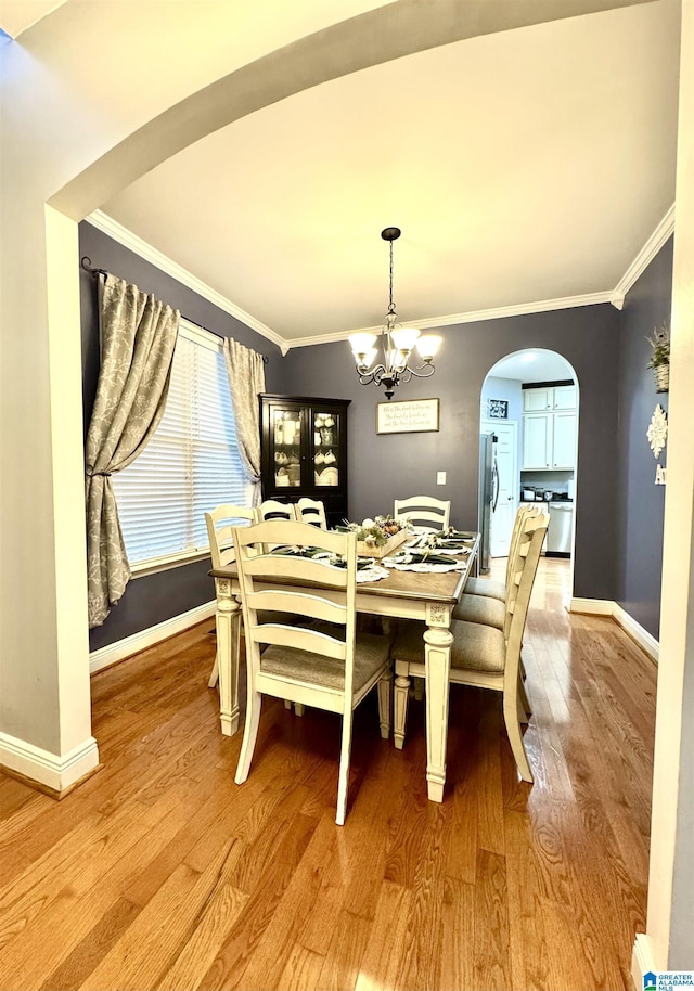 dining area featuring a chandelier, crown molding, and light hardwood / wood-style flooring