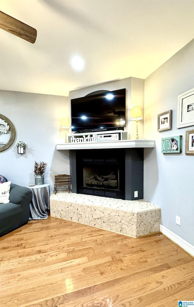 living room with ceiling fan, a fireplace, and hardwood / wood-style floors