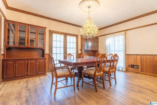 dining space featuring plenty of natural light, an inviting chandelier, and light hardwood / wood-style flooring