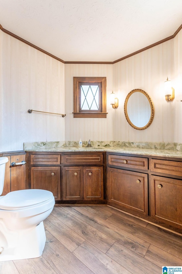 bathroom featuring hardwood / wood-style floors, toilet, vanity, and crown molding