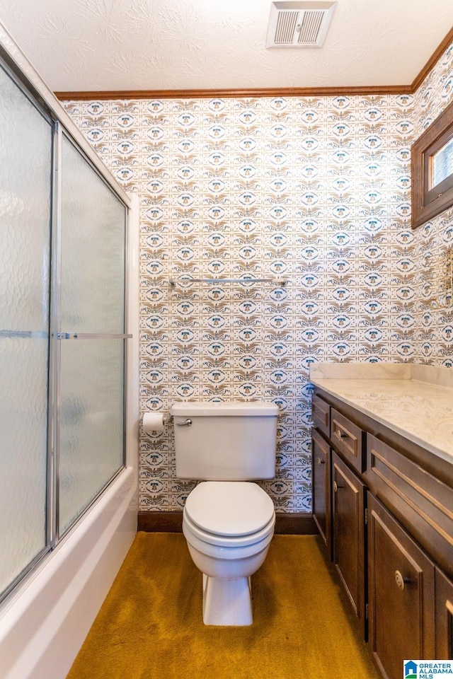 full bathroom featuring combined bath / shower with glass door, vanity, toilet, and crown molding