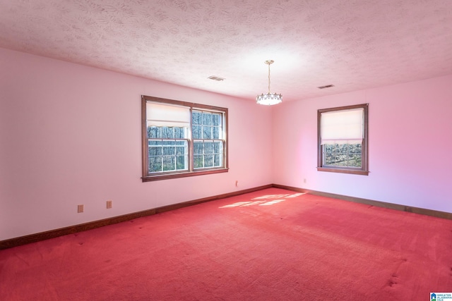 spare room featuring carpet floors and a textured ceiling