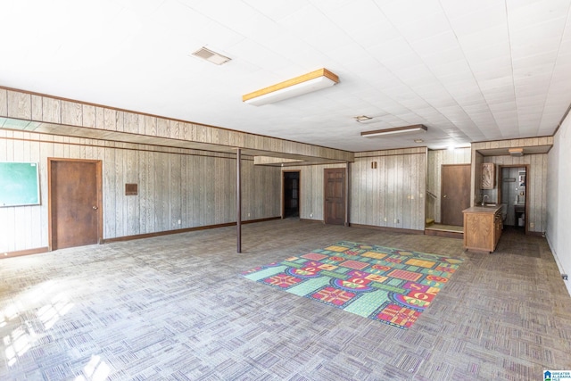 basement with wood walls and carpet flooring