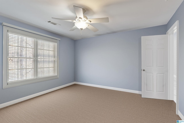 unfurnished room with ceiling fan and carpet