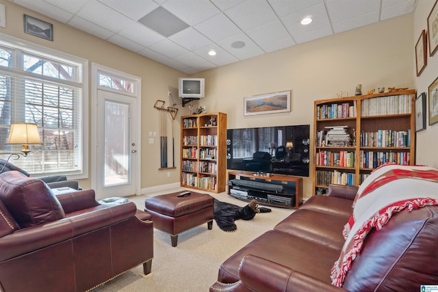 carpeted living room featuring a drop ceiling