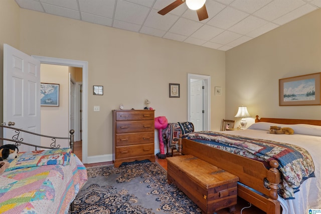 bedroom with ceiling fan, a paneled ceiling, and hardwood / wood-style flooring