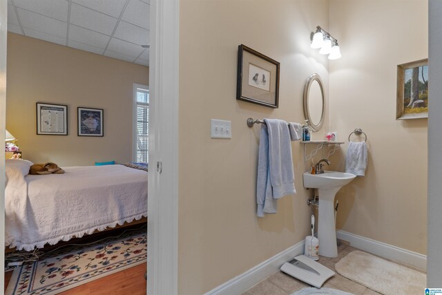 bathroom featuring a paneled ceiling and sink