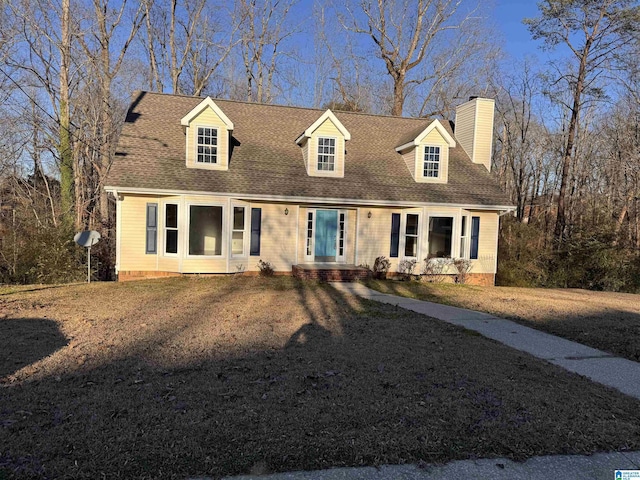 cape cod home featuring a front yard