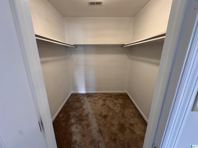 spacious closet featuring dark carpet