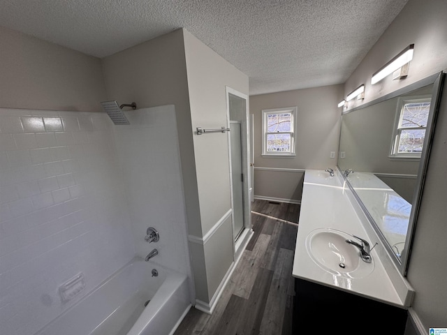 bathroom with vanity, hardwood / wood-style flooring, a textured ceiling, and shower / tub combination