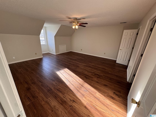 bonus room featuring ceiling fan, a textured ceiling, dark hardwood / wood-style floors, and lofted ceiling