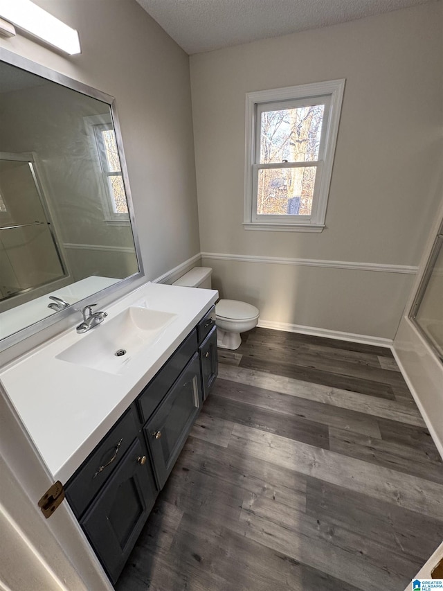 bathroom featuring a textured ceiling, toilet, hardwood / wood-style floors, and vanity