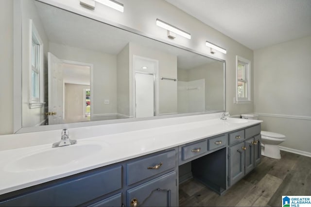 bathroom featuring toilet, hardwood / wood-style floors, vanity, and an enclosed shower