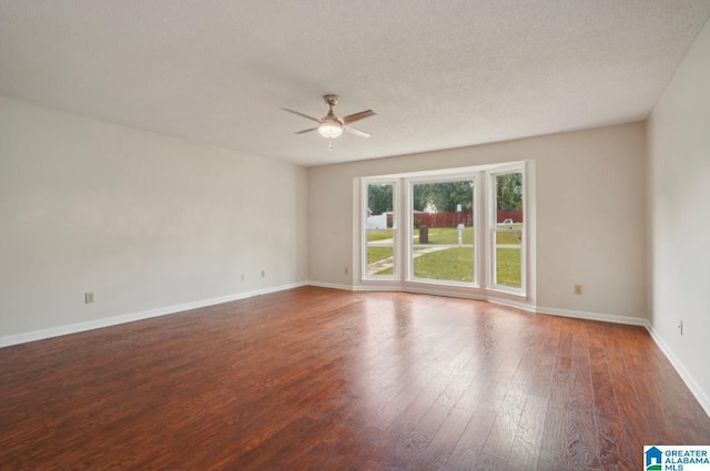 spare room with ceiling fan and dark hardwood / wood-style flooring