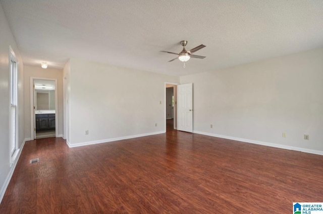 empty room featuring ceiling fan, dark hardwood / wood-style flooring, and a textured ceiling